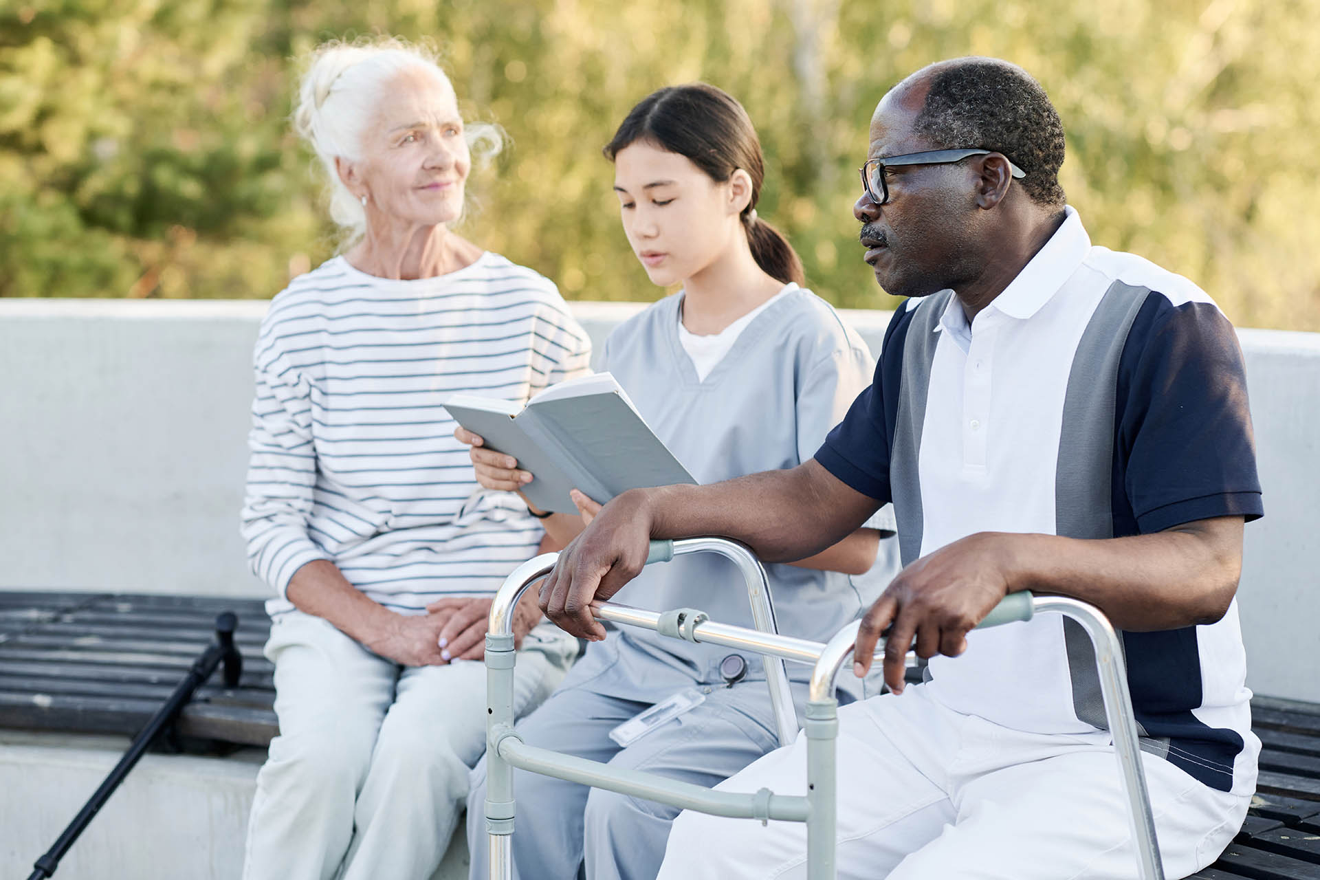 Caregiver reading book to senior people